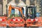 Roadworks. Workman operating digger on village street.