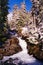 A roaring mountain stream in the Cascades in the winter with snow