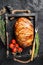 Roast bacon wrapped meatloaf, meat loaf in a tray with herbs. Black background. Top view