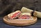 Roast beef panini with tomato, onion and cheese on a round cutting board