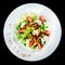Roast beef salad with tomatoes, cucumbers, feta cheese and pepper in white plate isolated on black background. Food background, m