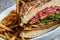 Roast Beef sandwich with french fries on artisanal bread with chopped red onions, cheese, lettuce and tomato