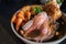 Roast beef slices on a plate with carrots, roast potatoes, a Yorkshire pudding and gravy, making a complete Sunday roast meal