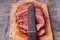 Roast beef slices on wooden cutting board with old knife