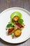 Roast chicken with fondant potatoes, pea mousse, pea puree, garlic flowers and nasturtium leaves