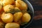 Roast golden potatoes seasoned with salt, garlic, rosemary and thyme on rustic wooden background