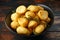 Roast golden potatoes seasoned with salt, garlic, rosemary and thyme on rustic wooden background