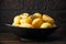 Roast golden potatoes seasoned with salt, garlic, rosemary and thyme on rustic wooden background