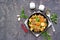 Roast, stewed beef with potatoes and carrots in a brown clay bowl on a dark concrete background