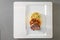 Roast venison, flat bread dumpling and round shaped cabbage vegetable, gourmet dish on a white plate, gray background, high angle