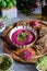 Roasted beet hummus in ceramic bowl, flax seed crackers on wooden cutting board, pesto sauce jar - vegetarian, vegan food concept