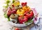 Roasted bell peppers with mushroom, rice, cheese and herbs filling in a baking dish on a white wooden table.