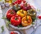 Roasted bell peppers with mushroom, rice, cheese and herbs filling in a baking dish on a white wooden table.