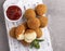 Roasted breaded mozzarella cheese balls with red sauce close up