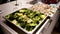 Roasted broccoli florets with lemon on baking tray, steam from the dish