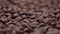 Roasted brown coffee beans. Organic invigorating product in the form a bunch of grains, close-up. Concept of texture in