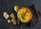 Roasted carrot and turmeric soup on a dark background