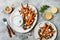 Roasted carrots lentil salad with feta, herb yogurt and dukkah on a light concrete background. Vegetarian food.