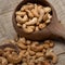 Roasted cashew nuts and halves in wooden bowl on table top view. Macro studio shot Homemade Roasted Salted Cashews in basket and