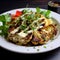 Roasted cauliflower steak with herbs and creamy sauce on white plate, close up. Healthy eating, plant based meat substitute