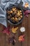 Roasted chestnuts with salt in cast iron grilling pan over rustic wooden board. Top view. Flat lay