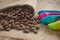 Roasted coffee beans, dose measuring spoons on jute sack