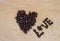 Roasted coffee shaped into heart and spelling the word love - image