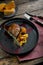 Roasted duck leg with confit pumpkin, closeup. Horizontal top view, top shot. Copy space, wooden background, low key