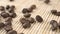 Roasted fresh arabica coffee beans fall on a textured bamboo mat