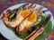 Roasted grilled giant river shrimp or prawn on green banana leaf on.vintage white zinc dish on beautiful fabric Thai style. Thai