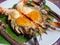 Roasted grilled giant river shrimp or prawn on green banana leaf on.vintage white zinc dish on beautiful fabric Thai style. Thai