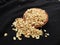 Roasted Groundnut or Peanut Pile in a red color plastic cup and traditional sand bowl with scattered on black background