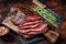 Roasted hanging tender or Onglet sliced beef meat steak on a butcher board with cleaver. Dark background. Top View