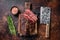 Roasted hanging tender or Onglet sliced beef meat steak on a butcher board with cleaver. Dark background. Top View