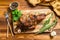 Roasted lamb, sheep leg on a cutting board with rosemary. wooden background. Top view