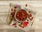 Roasted Natural Almond Nuts Badam in a porcelain bowl. Nuts spilled on bleached oak wood background.