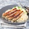 Roasted nuremberg sausages served with sour cabbage and mashed potatoes, on a gray plate, square