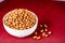 Roasted peanuts in white bowl on wooden background. Close up. Generative AI