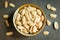 Roasted peeled salted peanuts in rustic bowl on wooden background