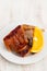 Roasted piglet with orange on white plate