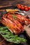 Roasted pork Bacon sizzling slices on wooden board. Wooden background. Top view