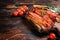 Roasted pork Bacon sizzling slices on wooden board. Wooden background. Top view. Copy space