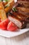 Roasted pork ribs, potatoes and tomatoes macro. vertical