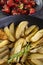 Roasted potatoes with rosemary in an iron casserole with confit tomatoes in the background