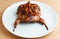 Roasted quail on a white plate