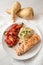 roasted salmon fillet with parsnip mash, tomato salad and parsley garnish, healthy diet dinner on a white plate and a white table