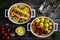 Roasted salmon steak with roast potatoes and tomatoes served in ceramic pan on wooden table