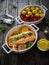 Roasted salmon steak with roast potatoes and tomatoes served in ceramic pan on wooden table