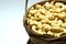 Roasted salted raw cashew nuts in wooden bowl on rustic table, healthy vegetarian snack, Anacardium occidentale, Cashews on white