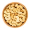 Roasted salted whole cashews in wooden bowl over white